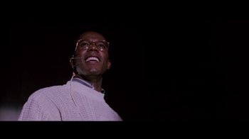 Movie still from “Die Hard” (1988), directed by John McTiernan – A man wearing glasses and a white sweater; Close Up shot, Low angle