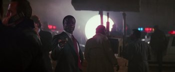 Movie still from “Die Hard” (1988), directed by John McTiernan – A man wearing a suit and tie holding a piece of paper; Medium shot, Low angle