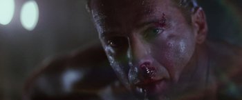 Movie still from “Die Hard” (1988), directed by John McTiernan – A man's face covered in blood; Close Up shot, Low angle