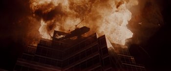Movie still from “Die Hard” (1988), directed by John McTiernan – A helicopter flying over a building that is on fire; Extreme Wide shot, Low angle