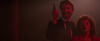 Movie still from “Die Hard” (1988), directed by John McTiernan – A man in a suit holding a cell phone in his hand; Close Up shot, Low angle