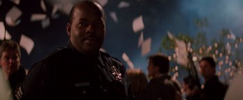 Movie still from “Die Hard” (1988), directed by John McTiernan – A police officer standing in front of a crowd of onlookers; Close Up shot, Low angle