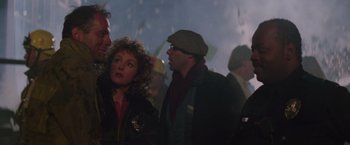 Movie still from “Die Hard” (1988), directed by John McTiernan – A group of people standing in a room; Close Up shot, Over the shoulder angle