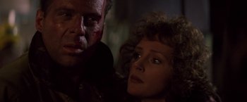 Movie still from “Die Hard” (1988), directed by John McTiernan – A man and a woman looking at the camera; Close Up shot, Low angle