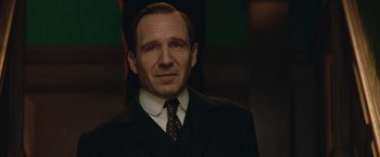 Movie still from “The King's Man” (2021), directed by Matthew Vaughn – A person wearing a suit and tie; Close Up shot, Over the shoulder angle