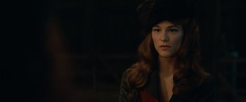 Movie still from “The King's Man” (2021), directed by Matthew Vaughn – A woman with long hair wearing a fur hat; Close Up shot, Over the shoulder angle