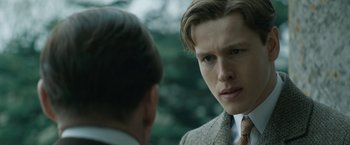 Movie still from “The King's Man” (2021), directed by Matthew Vaughn – A man in a suit and tie talking to another man in a suit and tie; Close Up shot, Over the shoulder angle
