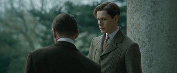 Movie still from “The King's Man” (2021), directed by Matthew Vaughn – A man in a suit and tie talking to another man in a suit and tie; Close Up shot, Over the shoulder angle
