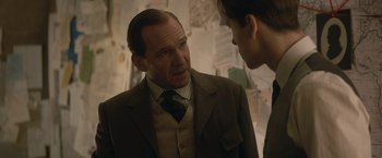 Movie still from “The King's Man” (2021), directed by Matthew Vaughn – A man wearing a suit and tie talking to another man wearing a tie; Close Up shot, Over the shoulder angle