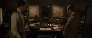 Movie still from “The King's Man” (2021), directed by Matthew Vaughn – Two men sitting at a table in front of a map; Wide shot, High angle