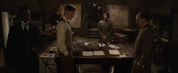 Movie still from “The King's Man” (2021), directed by Matthew Vaughn – Two men standing in front of a table with papers on it; Medium shot, High angle