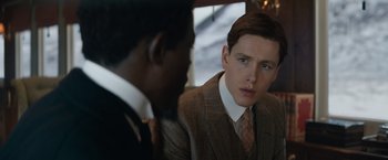Movie still from “The King's Man” (2021), directed by Matthew Vaughn – A man in a suit and tie looking at another man in a suit and tie; Close Up shot, Over the shoulder angle