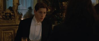 Movie still from “The King's Man” (2021), directed by Matthew Vaughn – A man in a tuxedo sitting in front of a christmas tree; Close Up shot, Over the shoulder angle