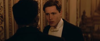 Movie still from “The King's Man” (2021), directed by Matthew Vaughn – A man in a tuxedo looking at himself in the mirror; Close Up shot, Over the shoulder angle