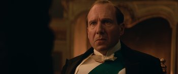 Movie still from “The King's Man” (2021), directed by Matthew Vaughn – A person wearing a suit and tie; Close Up shot, Low angle