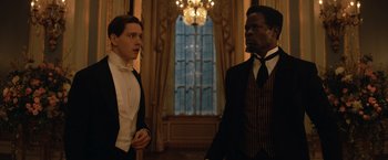 Movie still from “The King's Man” (2021), directed by Matthew Vaughn – Two men standing in front of a window in a room; Medium shot, Low angle