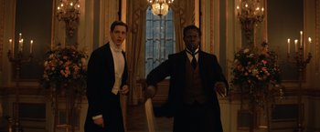 Movie still from “The King's Man” (2021), directed by Matthew Vaughn – Two men in suits and ties are in front of a window; Medium shot, Low angle