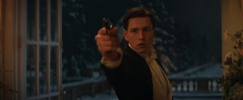 Movie still from “The King's Man” (2021), directed by Matthew Vaughn – A man in a tuxedo holding a gun in his hand; Close Up shot, Low angle