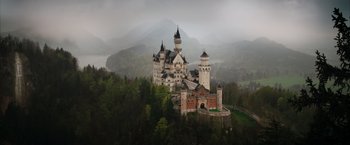 Movie still from “The King's Man” (2021), directed by Matthew Vaughn – A castle on top of a hill in the middle of a forest; Extreme Wide shot, Low angle