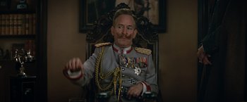 Movie still from “The King's Man” (2021), directed by Matthew Vaughn – A man in military uniform sitting in a chair; Close Up shot, Low angle