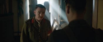 Movie still from “The King's Man” (2021), directed by Matthew Vaughn – A man in a uniform looking at himself in a mirror; Medium shot, Over the shoulder angle