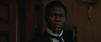 Movie still from “The King's Man” (2021), directed by Matthew Vaughn – A man in a suit with a beard and mustache; Close Up shot, High angle