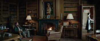 Movie still from “The King's Man” (2021), directed by Matthew Vaughn – A living room with a fireplace and a chair; Wide shot, High angle