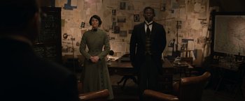 Movie still from “The King's Man” (2021), directed by Matthew Vaughn – A man and a woman standing next to each other in a room; Medium shot, Over the shoulder angle
