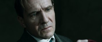 Movie still from “The King's Man” (2021), directed by Matthew Vaughn – A person wearing a suit and tie; Close Up shot, Over the shoulder angle