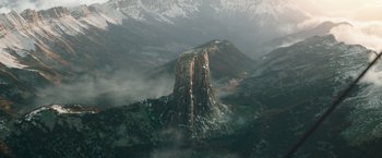Movie still from “The King's Man” (2021), directed by Matthew Vaughn – A tall rock in the middle of a mountain; Extreme Wide shot, High angle