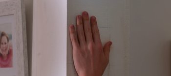 Movie still from “The Kissing Booth 3” (2021), directed by Vince Marcello – A person's hand reaching out of the corner of a wall; Extreme Close Up shot, Overhead angle
