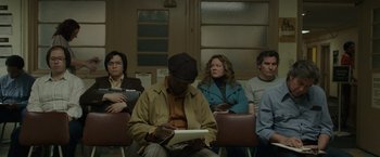 Movie still from “The Kitchen” (2019), directed by Andrea Berloff – A group of people sitting in a room; Medium shot, Low angle