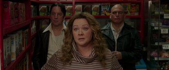 Movie still from “The Kitchen” (2019), directed by Andrea Berloff – A woman standing in front of two other people; Medium shot, Over the shoulder angle