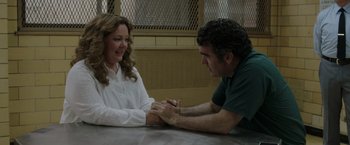 Movie still from “The Kitchen” (2019), directed by Andrea Berloff – A man and a woman holding hands on a table; Medium shot, Over the shoulder angle