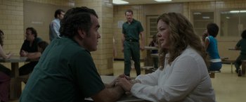 Movie still from “The Kitchen” (2019), directed by Andrea Berloff – A man and a woman sitting at a table in a room; Medium shot, Over the shoulder angle