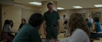 Movie still from “The Kitchen” (2019), directed by Andrea Berloff – A man in a green shirt standing next to two other people; Medium shot, Over the shoulder angle