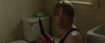 Movie still from “The Kitchen” (2019), directed by Andrea Berloff – A man holding a bloody knife in a bathroom; Close Up shot, Over the shoulder angle