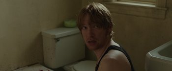 Movie still from “The Kitchen” (2019), directed by Andrea Berloff – A person in a bathroom near a toilet; Close Up shot, Over the shoulder angle