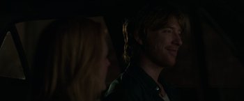Movie still from “The Kitchen” (2019), directed by Andrea Berloff – A man and a woman are smiling in the dark; Close Up shot, Over the shoulder angle