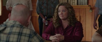 Movie still from “The Kitchen” (2019), directed by Andrea Berloff – A woman sitting at a table with a bottle of beer in front of her; Close Up shot, Over the shoulder angle