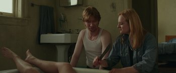 Movie still from “The Kitchen” (2019), directed by Andrea Berloff – A man and a woman in a bathroom holding a knife; Medium shot, Over the shoulder angle