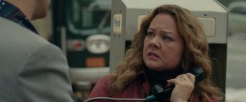Movie still from “The Kitchen” (2019), directed by Andrea Berloff – A woman with long curly hair is holding a phone; Close Up shot, Over the shoulder angle