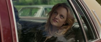 Movie still from “The Kitchen” (2019), directed by Andrea Berloff – A woman sitting in the back seat of a car looking out the window; Close Up shot, Over the shoulder angle