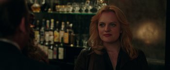 Movie still from “The Kitchen” (2019), directed by Andrea Berloff – A woman standing in front of a bar with bottles; Close Up shot, Over the shoulder angle