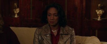 Movie still from “The Kitchen” (2019), directed by Andrea Berloff – A woman in a snakeskin print jacket and a red shirt; Close Up shot, High angle