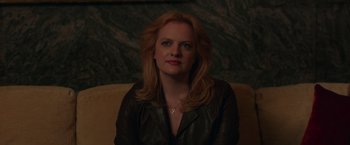 Movie still from “The Kitchen” (2019), directed by Andrea Berloff – A woman sitting on a couch wearing a leather jacket; Close Up shot, Over the shoulder angle