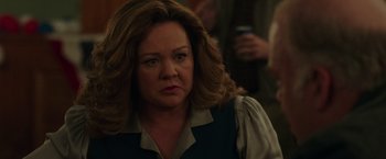 Movie still from “The Kitchen” (2019), directed by Andrea Berloff – An older woman with long brown hair looking at the camera; Close Up shot, Over the shoulder angle