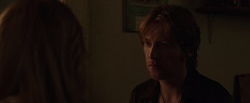 Movie still from “The Kitchen” (2019), directed by Andrea Berloff – A man with red hair is looking into the light; Close Up shot, Over the shoulder angle