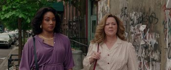 Movie still from “The Kitchen” (2019), directed by Andrea Berloff – Two women walking down the sidewalk in a city; Close Up shot, Over the shoulder angle