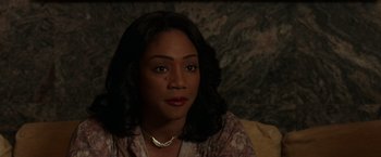 Movie still from “The Kitchen” (2019), directed by Andrea Berloff – A person sitting on a couch; Close Up shot, High angle